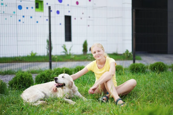 Miłość do zwierząt - młoda kobieta blonde odpoczynku z psem na trawie — Zdjęcie stockowe