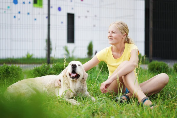 Miłość do zwierząt - młoda kobieta blonde odpoczynku z psem na trawie — Zdjęcie stockowe