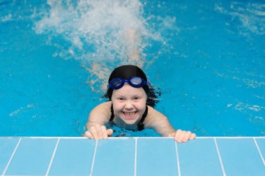 yüzme dersleri için çocuk havuzu - güzel tenli kız suda yüzüyor.