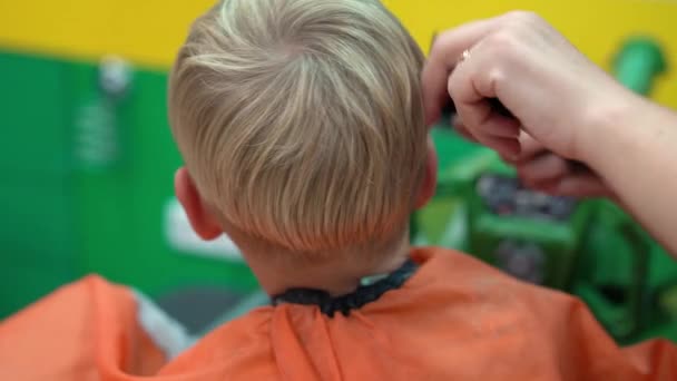 Haarschnitt eines kleinen Jungen im Kinderfriseursalon — Stockvideo