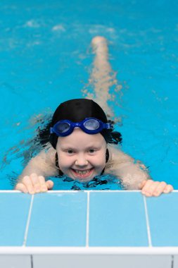 yüzme dersleri için çocuk havuzu - güzel tenli kız suda yüzüyor.