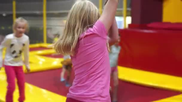 Happy childhood of a modern child in the city - girl jumping in the trampoline park — Stock Video