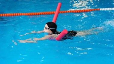 yüzme dersleri için çocuk havuzu - güzel tenli kız suda yüzüyor.