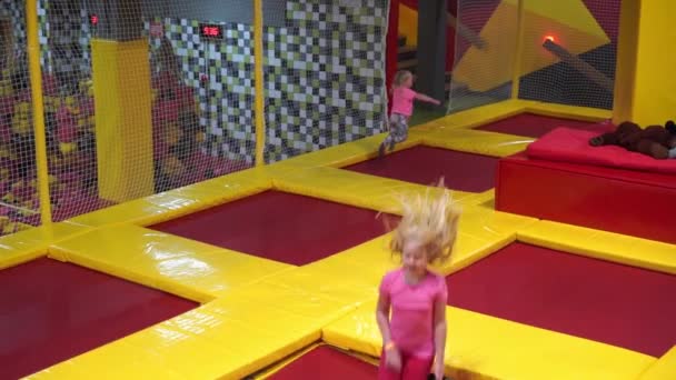 Feliz infancia de un niño moderno en la ciudad - niña saltando en el parque de trampolín — Vídeo de stock
