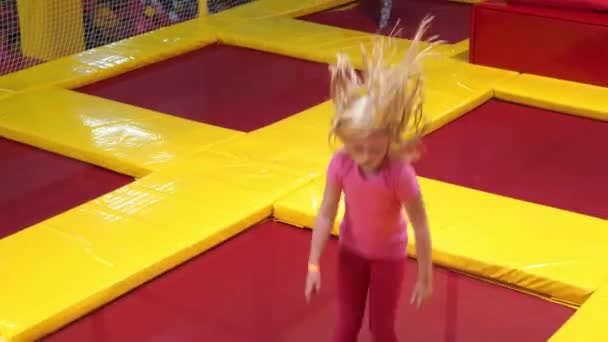 Счастливое детство современного ребенка в городе - девушка прыгает на батуте парка — стоковое видео