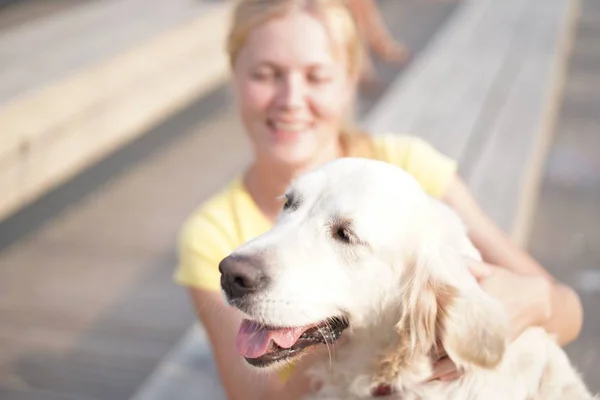 Amor por las mascotas - una joven rubia descansando con su perro en la calle —  Fotos de Stock