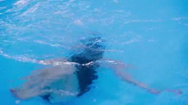 yüzme dersleri için çocuk havuzu - güzel tenli kız suda yüzüyor.