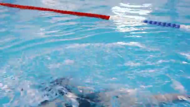 Lezioni di nuoto per bambini in piscina - bella ragazza dalla pelle chiara nuota in acqua — Video Stock