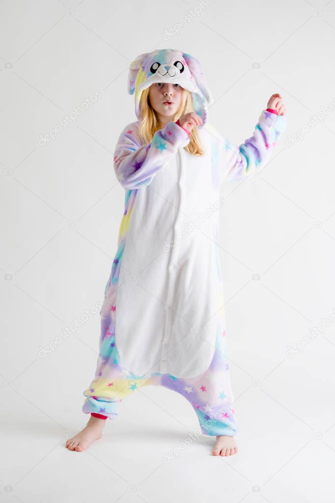 cheerful little boy posing on a white background in pajamas, blue shark costume