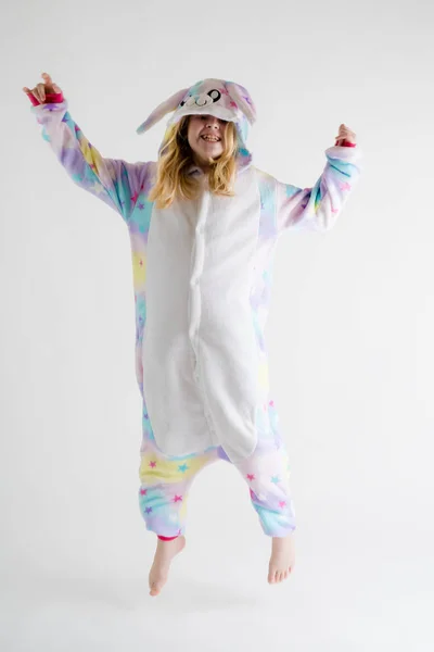 Niño alegre posando sobre un fondo blanco en pijama, traje de tiburón azul — Foto de Stock