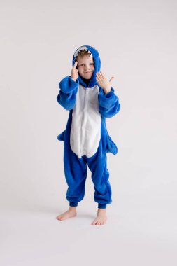 neşeli küçük çocuk pijama, mavi köpekbalığı kostüm beyaz bir arka plan üzerinde poz