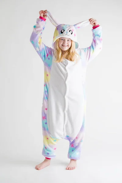 Modern mode - vacker blond tjej som poserar på en vit bakgrund i kigurumi pyjamas, bunny kostym — Stockfoto