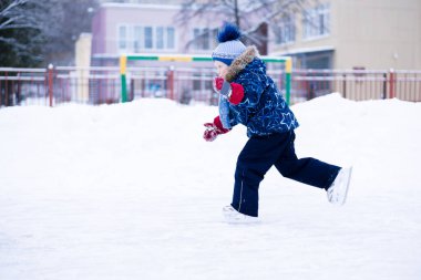 etkin kış tatili - şirin küçük çocuk bir buz pistinde paten