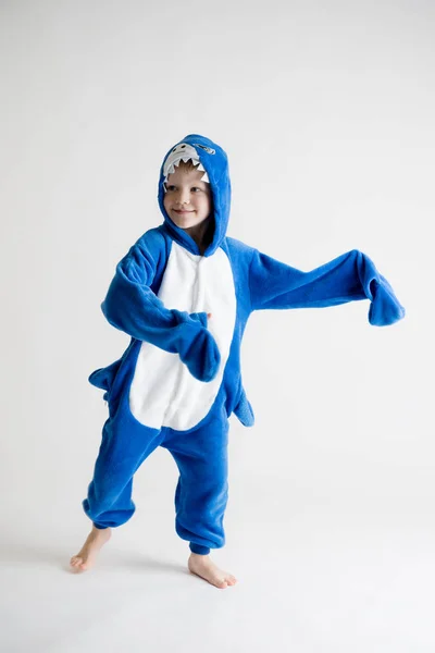 Wesoły chłopiec pozowanie na białym tle w piżamie, rekin błękitny strój — Zdjęcie stockowe