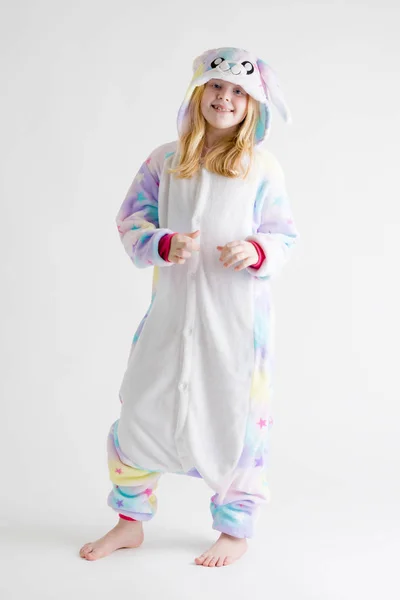 Modern mode - vacker blond tjej som poserar på en vit bakgrund i kigurumi pyjamas, bunny kostym — Stockfoto