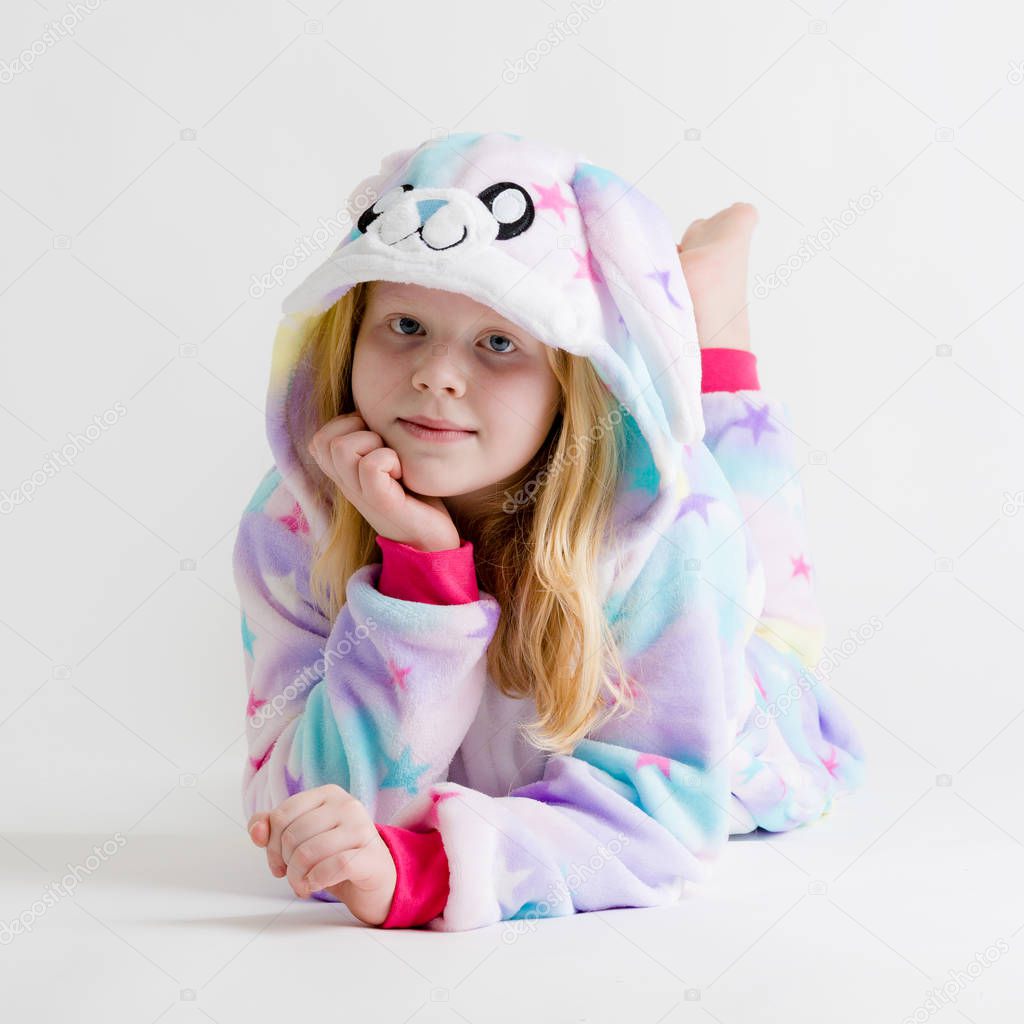 modern fashion - beautiful blonde girl posing on a white background in kigurumi pajamas, bunny costume