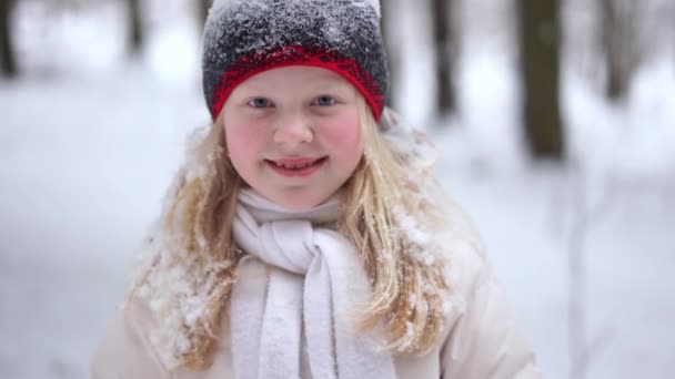 Porträtt av en vacker blond flicka i skogen vintern med fallande snö — Stockvideo