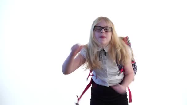 Bela estudante com uma mochila escolar e vestindo óculos dançando no estúdio em um fundo branco — Vídeo de Stock