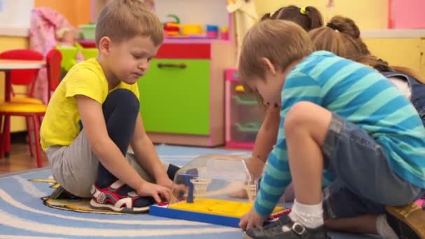 Voorschoolse educatie - gelukkige kinderen in de kleuterschool hebben plezier spelen samen — Stockvideo