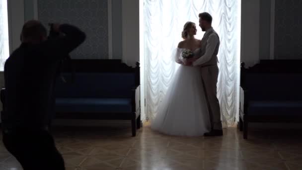 Fotografía de boda entre bastidores - fotógrafos profesionales toman fotos de recién casados en una habitación elegante — Vídeo de stock