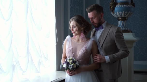 Szép newlywed pár pózol a drága sikkes fedett, az ablak, lassú mozgás — Stock videók