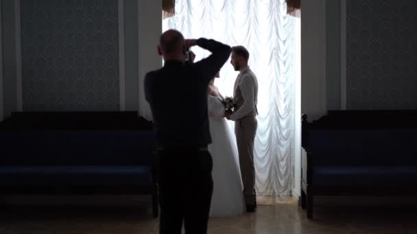 后台婚纱摄影--专业摄影师在别致的房间里为新婚夫妇拍照 — 图库视频影像