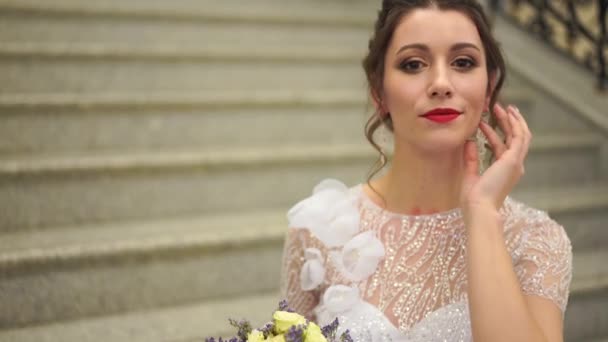 Portrait d'une mariée sexy dans une robe de mariée dans une chambre luxueuse sur les marches — Video