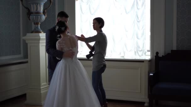 Fotografía de boda entre bastidores - fotógrafos profesionales toman fotos de recién casados en una habitación elegante — Vídeo de stock