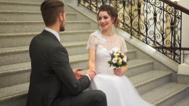 Hermosa pareja recién casada posando en el elegante interior caro en los escalones — Vídeos de Stock