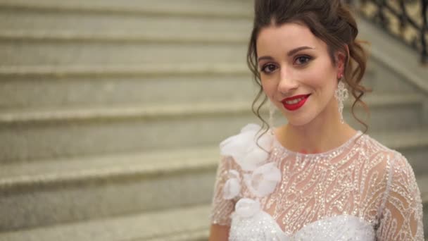 Портрет сексуальной невесты в свадебном платье в роскошной комнате на ступеньках — стоковое видео