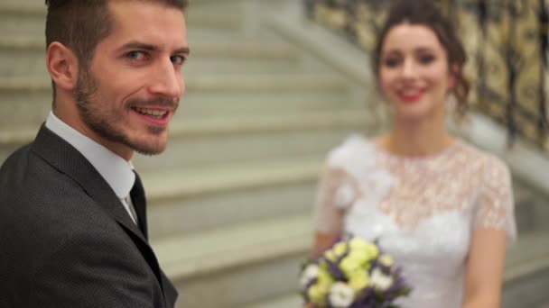 Mooie jonggehuwde paar poseren in de dure chic binnen op de stappen — Stockvideo