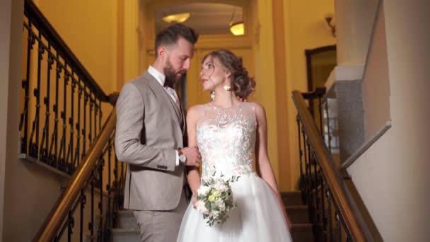 Beautiful newlywed couple posing in the chic expensive indoor on the steps — Stock Video