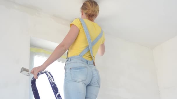 Dairede onarım-Avrupa görünümü genç bir kadın evde onarım yapar — Stok video