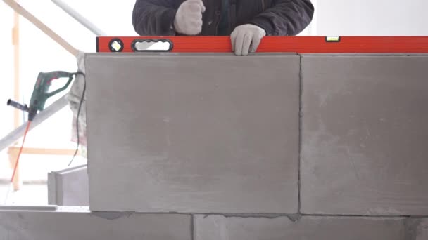 Bau und Reparatur - Montage einer Zwischenraum-Trennwand aus Nut-Feder-Blöcken — Stockvideo