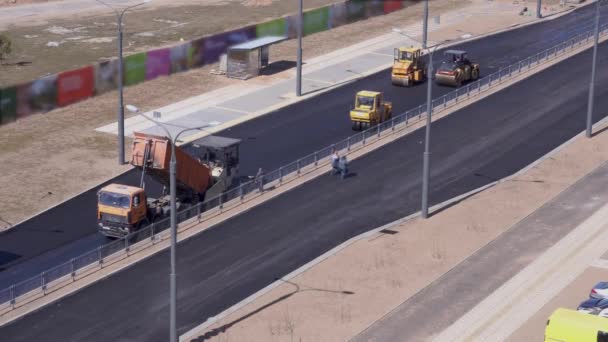 Obras rodoviárias - trabalhadores leigos asfalto na cidade. visão geral — Vídeo de Stock