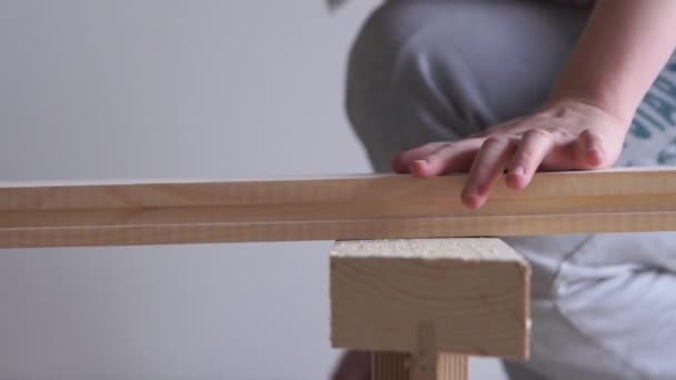 Une femme fait un travail non féminin scier une planche de bois avec un puzzle électrique — Video