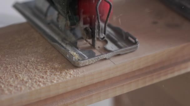 Krása pomalého pohybu ve stavebnictví a opravě-člověk pilou dřevěné desky s elektrickým skládačka — Stock video