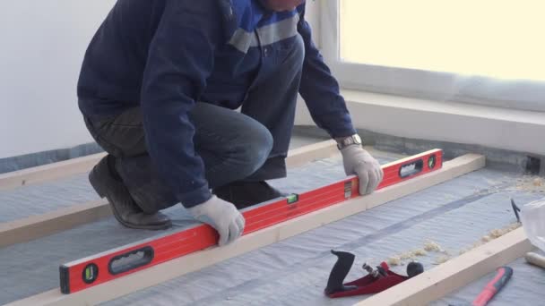 Master carpenter mounts pine wood floor - eco-friendly flooring. screwing lag to concrete. — Stock Video