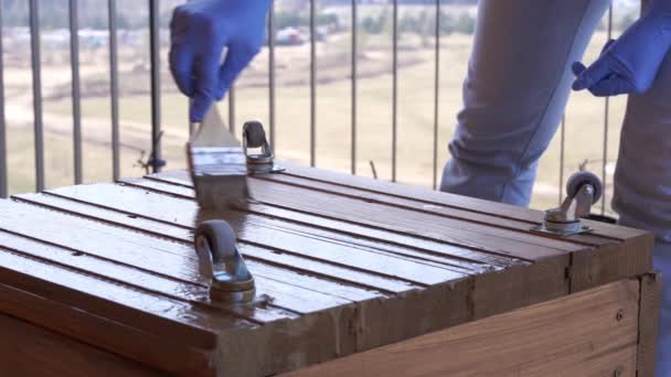 Садівництво та садівництво - жінка на терасі малює дерев'яну коробку для посадки крупним планом — стокове відео