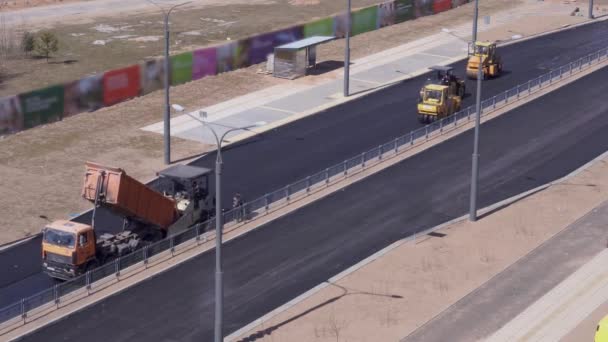 Obras de carretera - los trabajadores ponen asfalto en la ciudad. vista general, vídeo acelerado — Vídeos de Stock