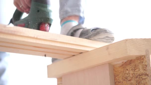 Uomo segare una tavola di legno con un puzzle elettrico primo piano — Video Stock