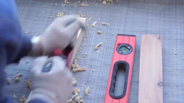 O carpinteiro principal monta o soalho de madeira de pinheiro - revestimento ecológico. parafuso lag para concreto . — Vídeo de Stock