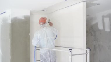 daire onarım - profesyonel ressam beyaz boya sprey tabancası ile duvarları boyar