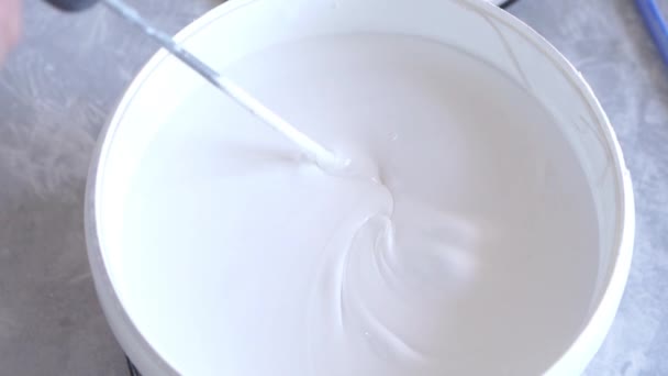 Belleza cámara lenta. reparación del apartamento - primer plano de pintura interior blanca con una batidora — Vídeo de stock