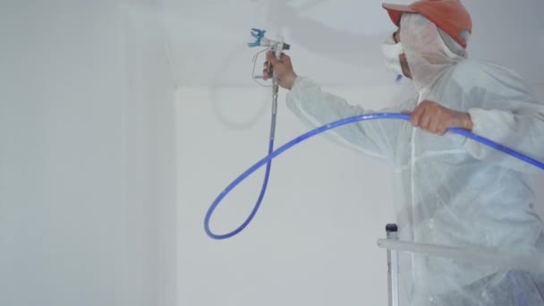 Belleza cámara lenta. reparación del apartamento - pintor profesional pinta las paredes con pistola de pintura blanca — Vídeo de stock