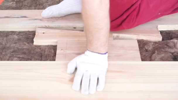 Träbearbetning i huset-en ung professionell hane monterar en furu trägolv — Stockvideo