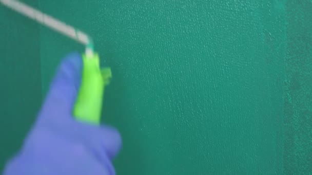 Reparación del apartamento - pintor profesional pinta las paredes con rodillo de pintura verde — Vídeos de Stock