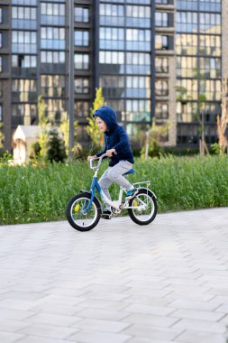 modern bir Avrupa şehrinde güvenlik. Küçük bir mutlu çocuk çok katlı bir kentsel binada kapalı bir avlu dan bir bisiklet sürmek.