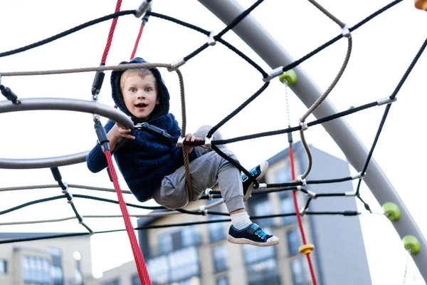 A little boy is having fun playing on the modern urban European playground — Stock Photo, Image