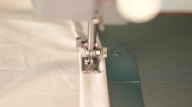 Güzellik yavaş hareket. evde çalışmak. parlak bir odada bir daktilo genç sarışın kadın sews